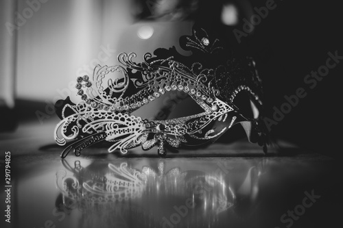 A black and white portrait of a venetian mask emitting mystery and excitement. The mask is ready to be used for carnaval, a masked ball or halloween.