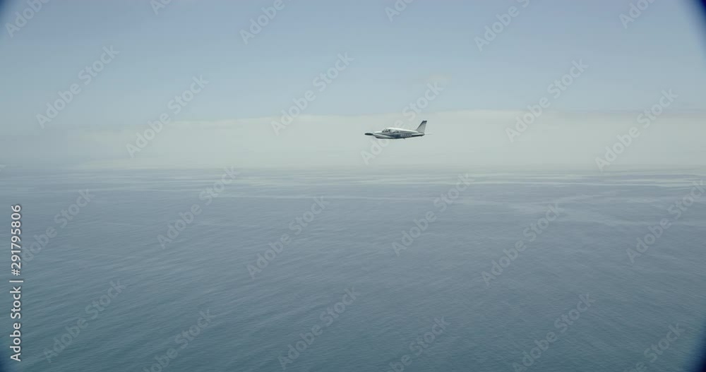 Helicopter aerial shot moving closer to jet plane midair, foggy day