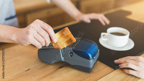 Close up of man paying with credit card in cafe for coffee