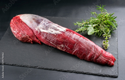 Fototapet Dry aged beef fillet steak natural as closeup on black background with copy spac
