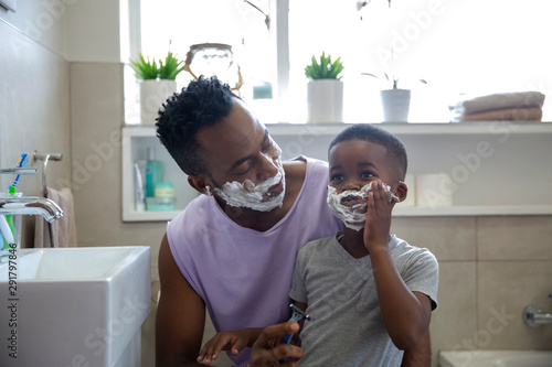 Father and son playing with shaving cream in the bathroom