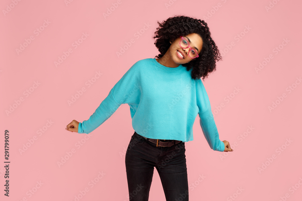 Photo of excited african american young woman dancing over pink background. Photo of excited african american young woman dancing over pink background.