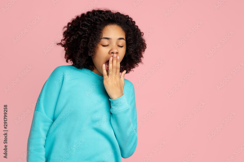 Tired african american young woman yawning over pink background. Sleepy inattentive deprived black female feeling somnolent lazy bored. Tired african american young woman yawning over pink background. Sleepy inattentive deprived black female feeling somnolent lazy bored.