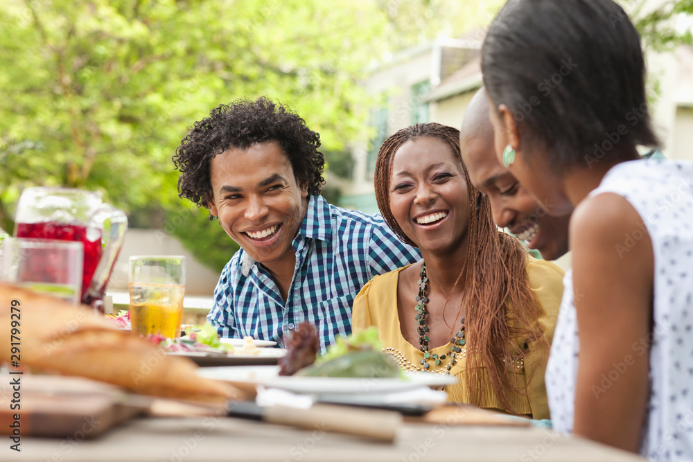 Four friends laughing at the lunch table Four friends laughing at the lunch table