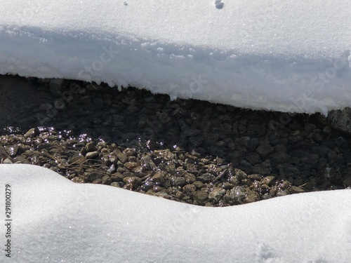 Kleiner Bach mit Kiesbett im Schnee photo