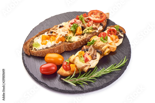 Spanish Tapas and Pinchos with cottage cheese, tomatoes, champignon mushrooms, zucchini, garlic and herbs on a stone plate, Italian Bruschetta, isolated on white background