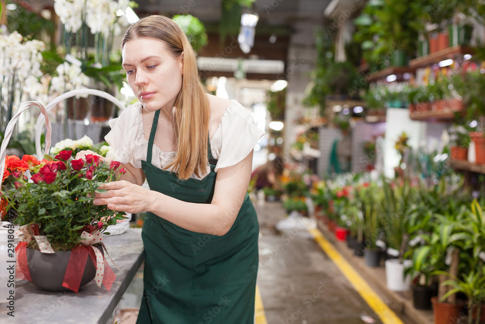 Portrait of florist with basket of red roses in flower shop