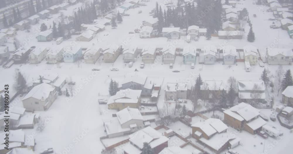 Aerial helicopter shot, overhead closeup on suburban town during snowstorm, drone footage Aerial helicopter shot, overhead closeup on suburban town during snowstorm, drone footage