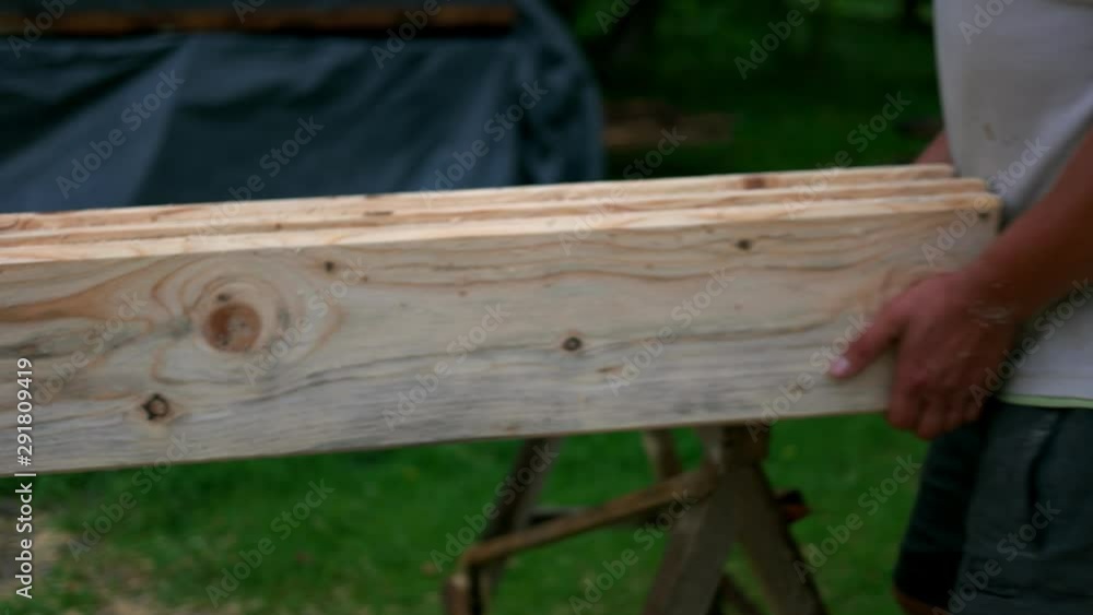 Builders working at construction site. Men carrying wood close up. Woodwork concept. Builders working at construction site. Men carrying wood close up. Woodwork concept.