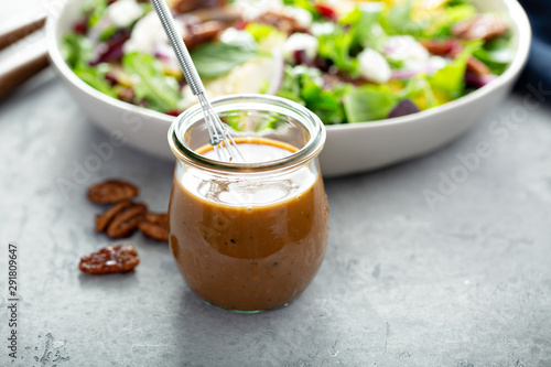 Balsamic vinaigrette dressing for a salad, small glass jar with a whisk photo