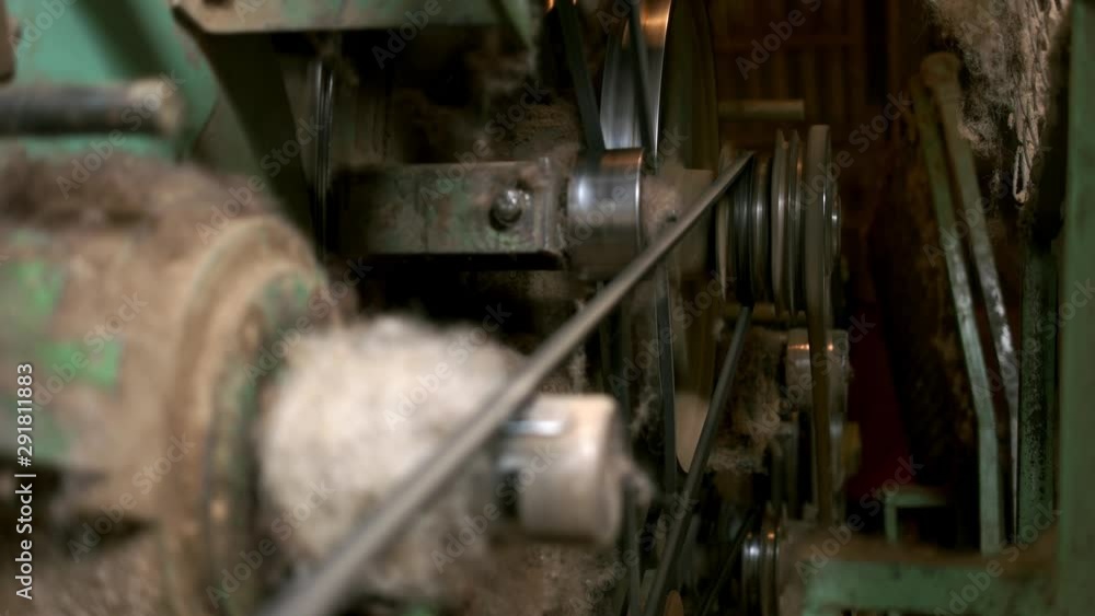 Old wool processing machine close up. Close up of belt and shaft of wool mill. Equipment and technology at textile factory. Old wool processing machine close up. Close up of belt and shaft of wool mill. Equipment and technology at textile factory.