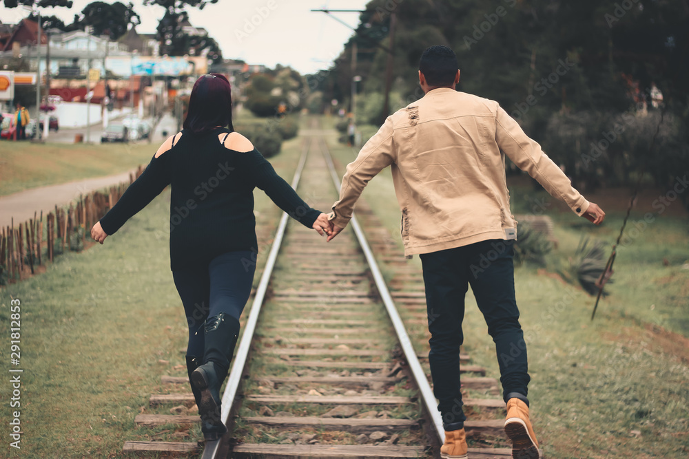 casal andando na linha do trem casal andando na linha do trem