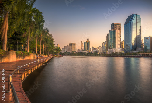 Lake with Wooden Walk Way in City Park. View of Benjakiti Park at Sunrise. Beautiful Morning Scene of Public Park in Bangkok  Thailand  Asia.