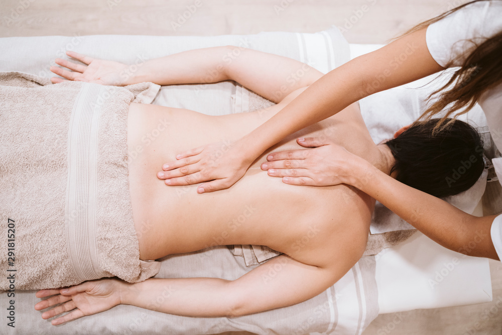 Fototapeta premium young caucasian Woman receiving back massage from physiotherapist female in clinic. Physiotherapy