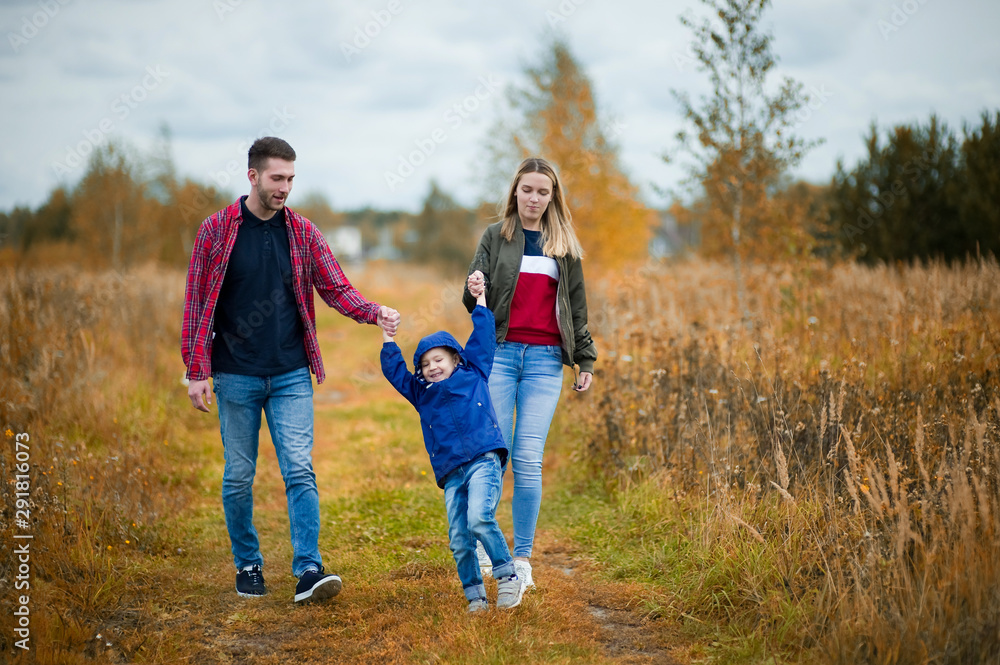 a young family of three on a spring day walks in a country a young family of three on a spring day walks in a country