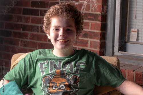 Smiling young boy in front of brick backdrop