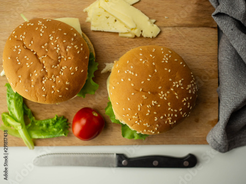 Obraz na plátně Domowe burgery z mięsem, serem, sałatą, pomidorem. Widok z góry.