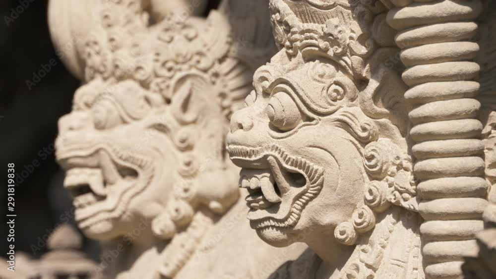 Close up rack focusing between two ornate sculptures of faces Close up rack focusing between two ornate sculptures of faces