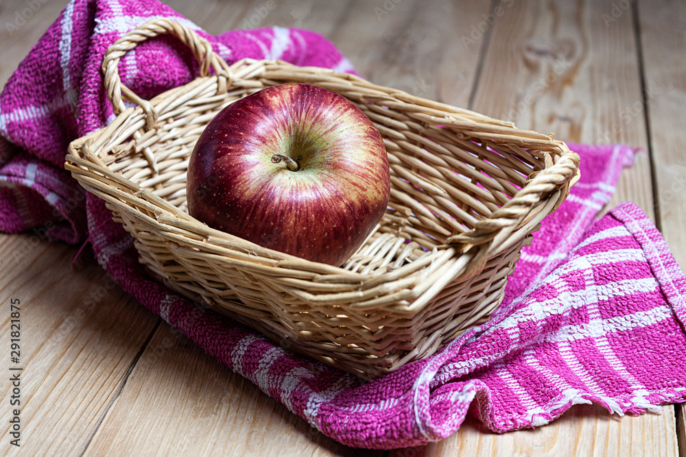 RED APPLE IN WICKER BASKET ON KITCHEN CLOTH AND WOODEN TABLE. HEALTHY FOOD RED APPLE IN WICKER BASKET ON KITCHEN CLOTH AND WOODEN TABLE. HEALTHY FOOD