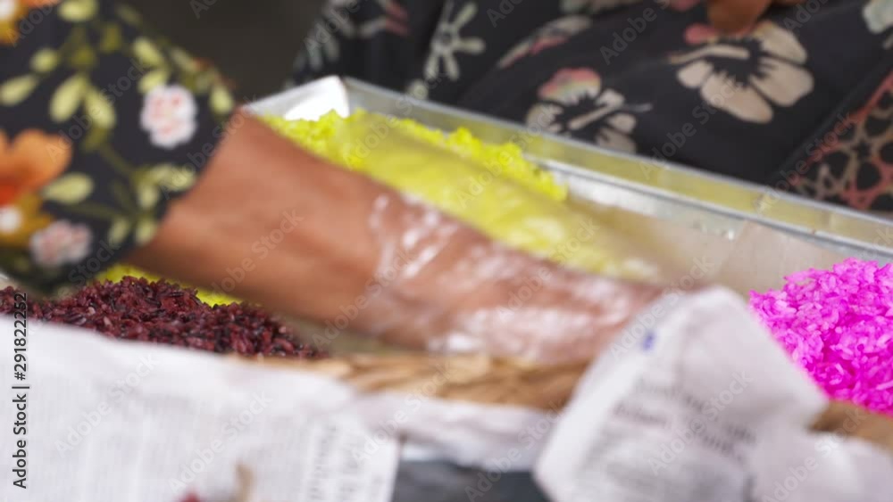 A tray with a variety of food, and a server's gloved hand organizing it A tray with a variety of food, and a server's gloved hand organizing it