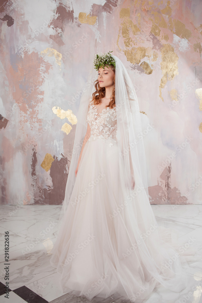 Portrait of a young beautiful woman in wedding dress with wreath and bouquet of fresh flowers. Portrait of a young beautiful woman in wedding dress with wreath and bouquet of fresh flowers.