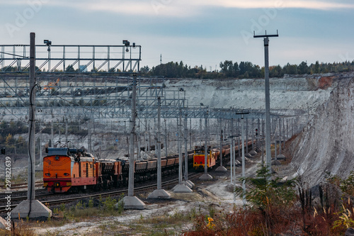 Freight train with ore in open mining quarry photo