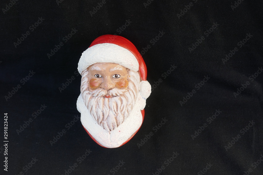 Face of a Santa Claus with beard and red cap. Close up, isolated on black background