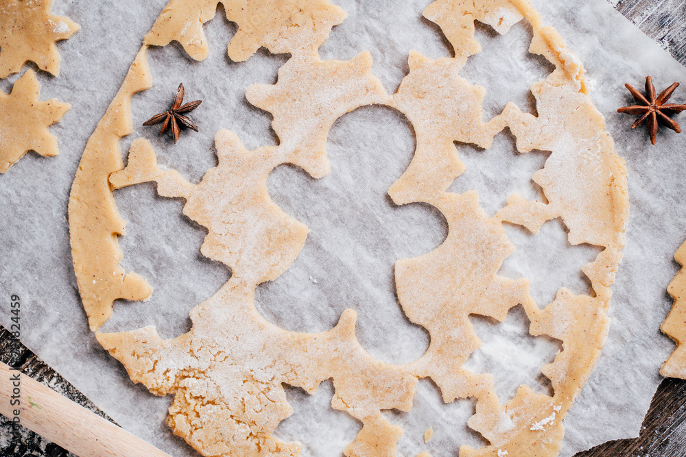 Christmas and New Year celebration traditions. Family home bakery, cooking traditional festive sweets. Gingerbread dough with christmas theme shapes and raw cookies Christmas and New Year celebration traditions. Family home bakery, cooking traditional festive sweets. Gingerbread dough with christmas theme shapes and raw cookies