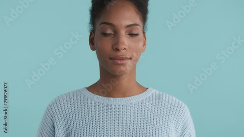 Portrait of beautiful african american girl confidently looking in camera over blue background