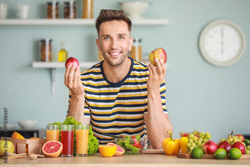 Handsome man with healthy products in kitchen. Weight loss concept Handsome man with healthy products in kitchen. Weight loss concept