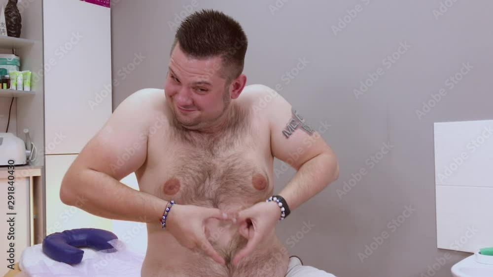 Handsome man gets up from the couch after hair removal. Handsome man gets up from the couch after hair removal.