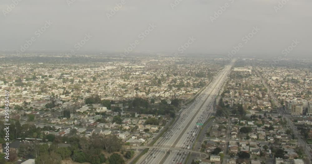 Aerial shot, day, high altitude shot of major highway in los angeles, metro train approaches, drone Aerial shot, day, high altitude shot of major highway in los angeles, metro train approaches, drone