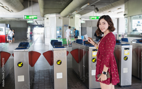 Woman holding train ticket to entrance gate