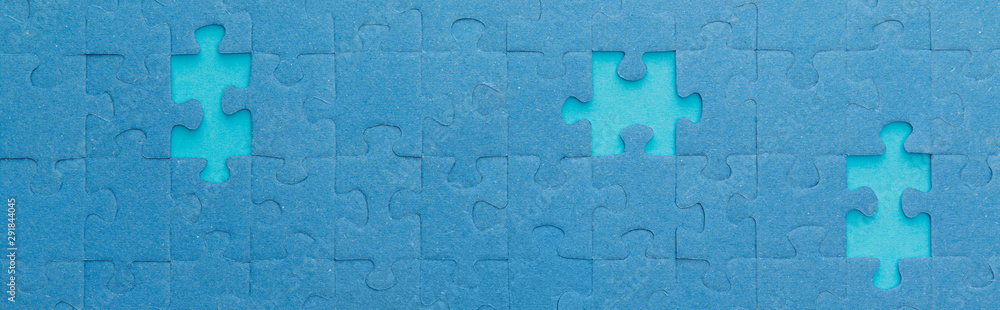 panoramic shot of blue jigsaw puzzle with lighter gaps panoramic shot of blue jigsaw puzzle with lighter gaps