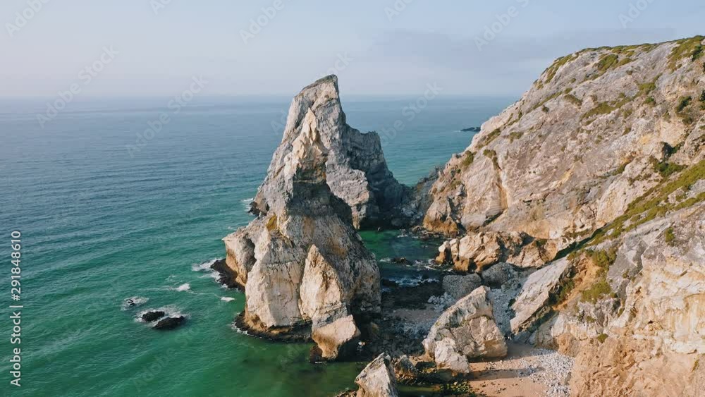 Aerial circle fly around rocky cliffs of Praia da Ursa beach located on Atlantic coast in Sintra, Portugal. Europe Aerial circle fly around rocky cliffs of Praia da Ursa beach located on Atlantic coast in Sintra, Portugal. Europe