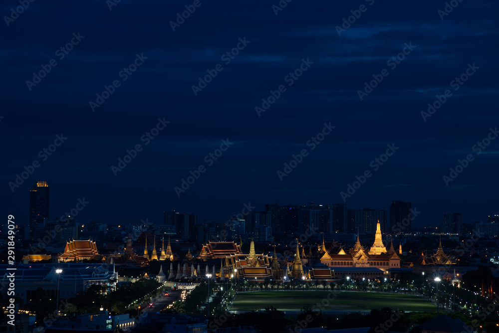Glowing gold light of Buddhist temple at twilight time, Bangkok, Thailand