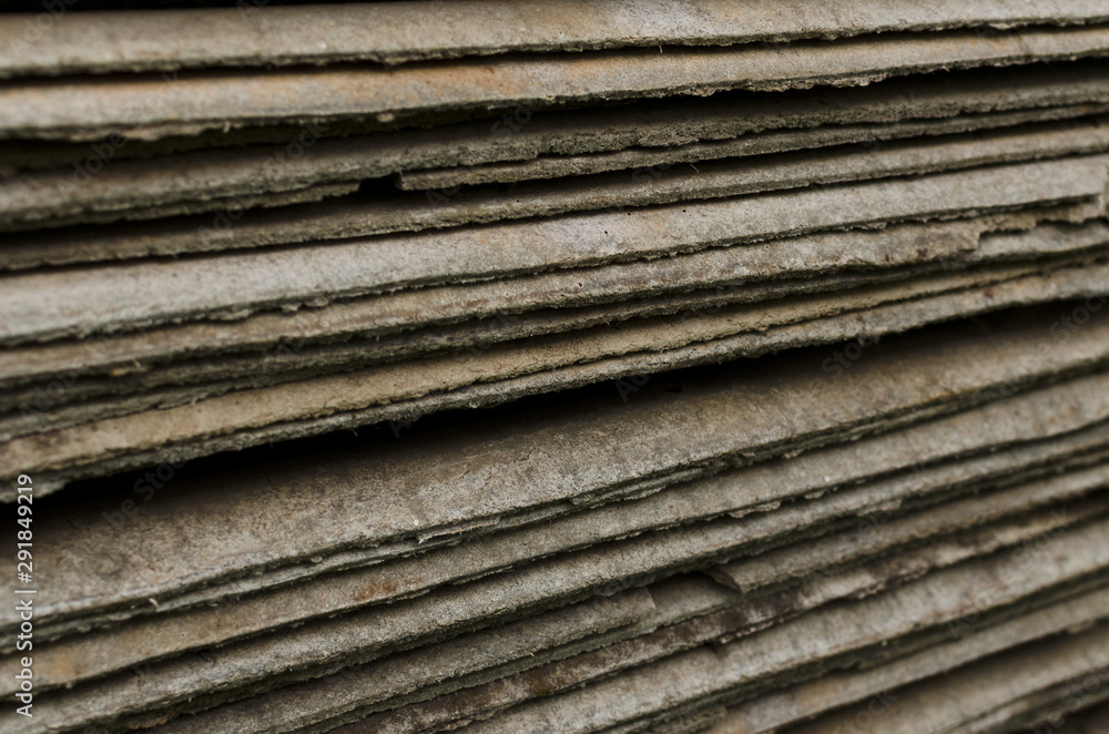 Stack of old asbestos slate roof sheets pattern closeup