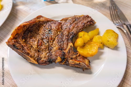 Plate of delicious grilled beef ribs and roasted potato