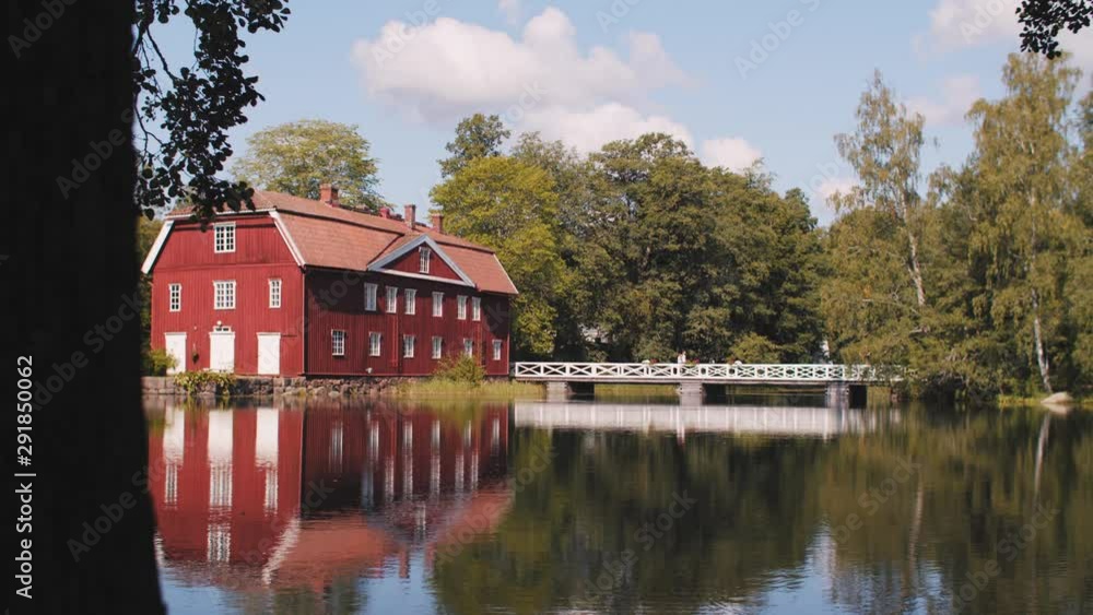 A SLIDER SHOT of a house by a lake on a bright sunny day. A SLIDER SHOT of a house by a lake on a bright sunny day.