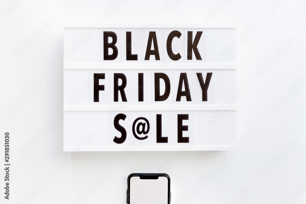 Creative promotion composition Black friday sale text on lightbox and mobile phone on white background. Flat lay, top view, overhead, mockup, copy space, template