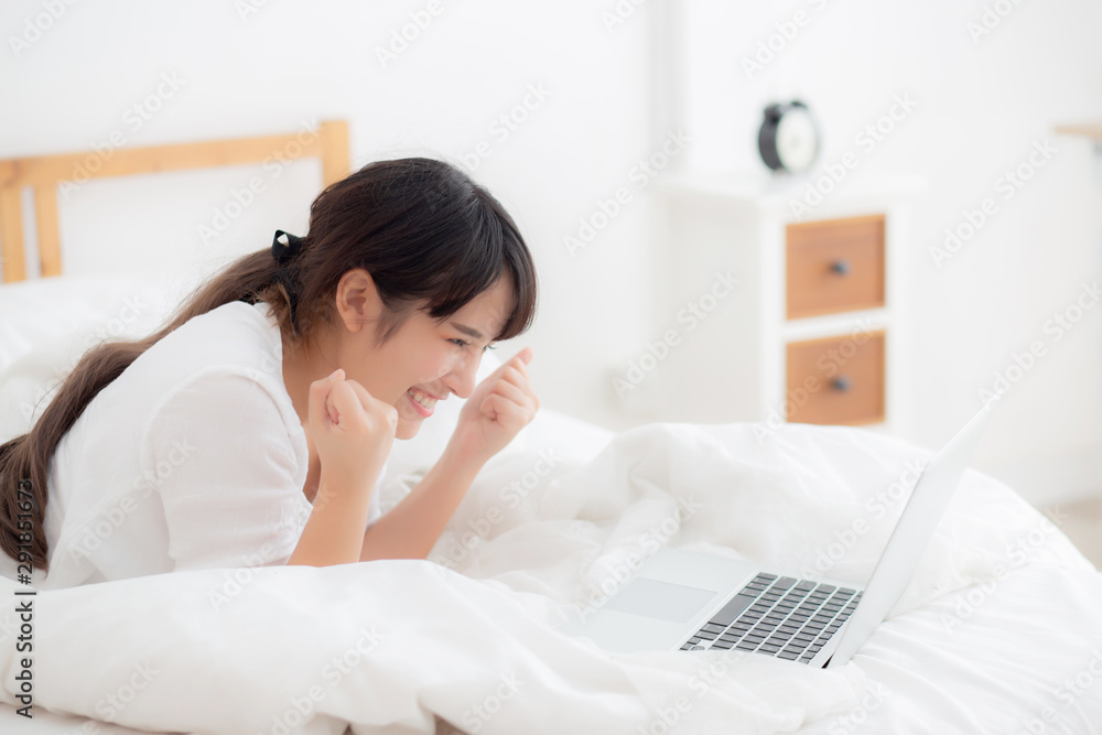 Beautiful portrait freelance asian young woman lying relax and leisure working laptop computer internet online on bed in bedroom, cheerful asia girl with gesture glad and success, lifestyle concept. Beautiful portrait freelance asian young woman lying relax and leisure working laptop computer internet online on bed in bedroom, cheerful asia girl with gesture glad and success, lifestyle concept.