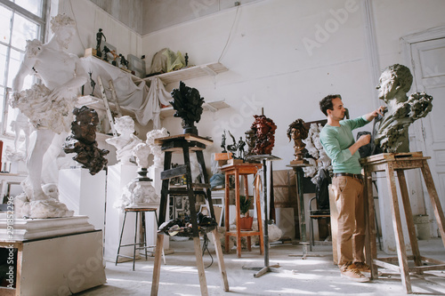 Inspired man working on sculpture in studio