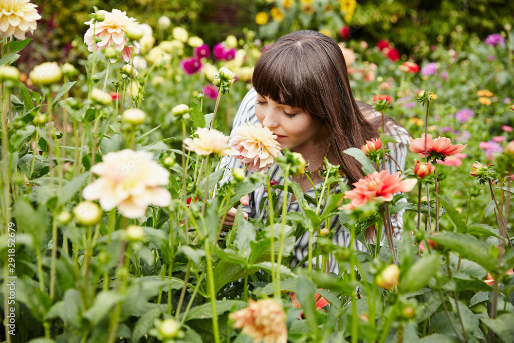 Woman smelling flowers in a garden on a farm Woman smelling flowers in a garden on a farm