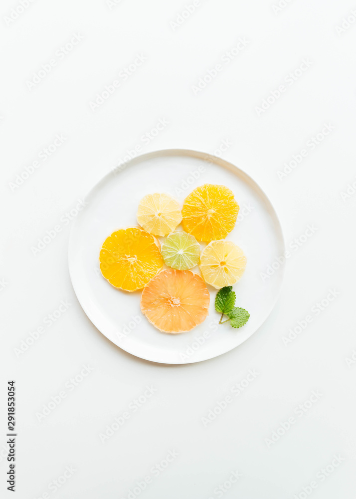 Sliced citrus salad with maple syrup on white plate with mint leaves Sliced citrus salad with maple syrup on white plate with mint leaves
