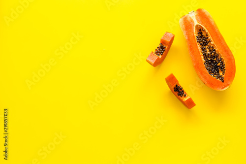 Exotic fruit. Papaya slises on yellow background top view space for text photo