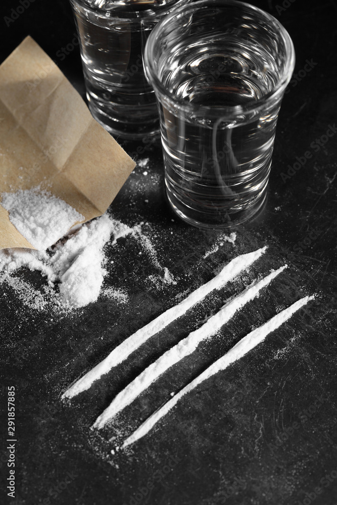 Foto Stock close up pile of cocaine in paper and vodka on black