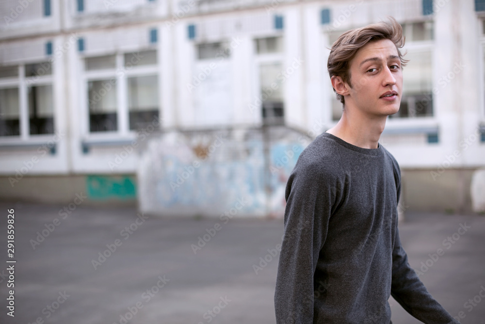 Portrait of a young guy of model appearance next to a building Portrait of a young guy of model appearance next to a building