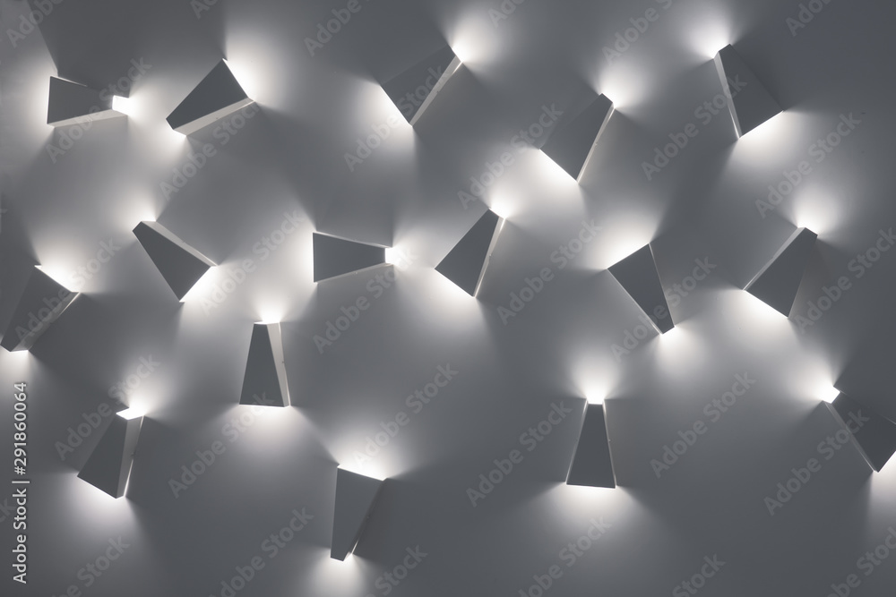 Light fixtures, unusual ceiling lamps. Design pattern. Cold lights. White colors of pattern. Modern design lighting. Contemporary interior lightning design. Modern indoor lighting concept - obrazy, fototapety, plakaty 