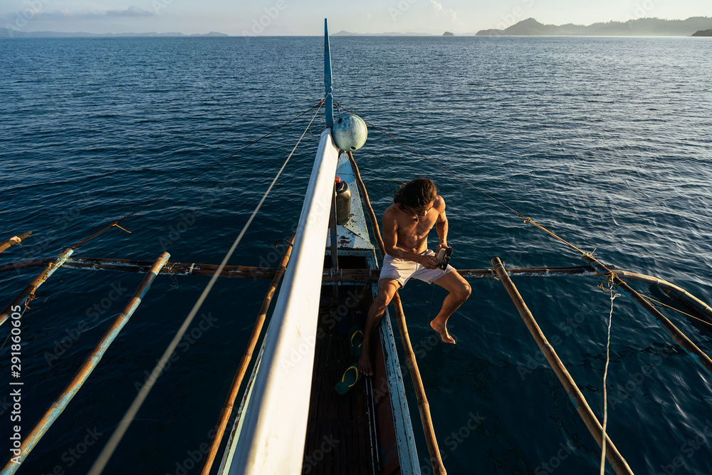 Asian man fishing on boat