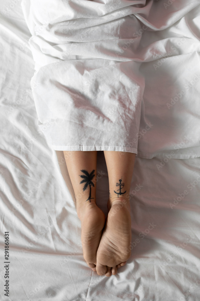 Tattooed young woman sleeping in a bed Tattooed young woman sleeping in a bed
